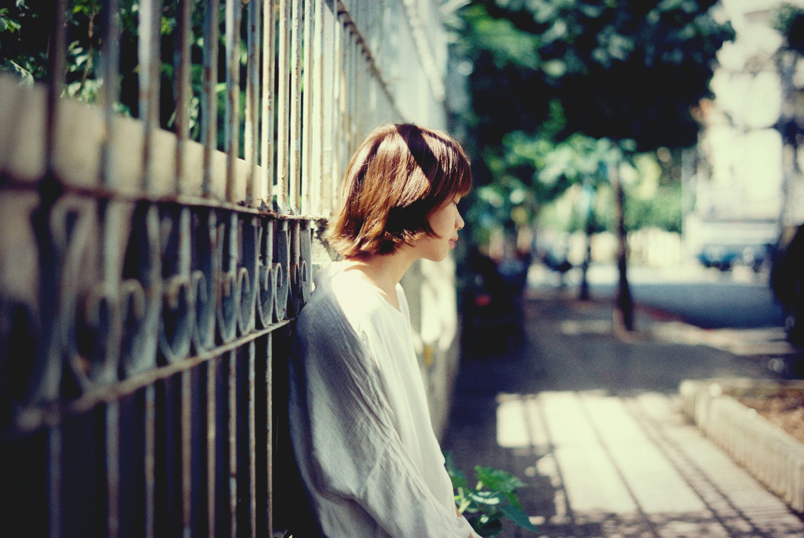 Girl alone on the sidewalk looking sad.